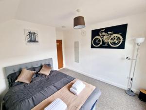 1 dormitorio con 1 cama y una foto de una motocicleta en la pared en JPL Apartment en Cardiff
