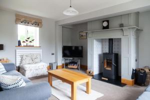 a living room with a couch and a fireplace at Stunning lodge in idyllic rural Herefordshire in Dorstone