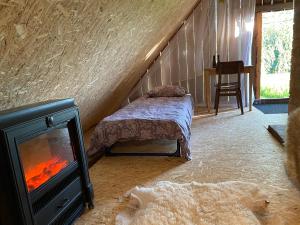 a bedroom with a fireplace and a bed and a stove at Karula Stay Sauna House in Karula National Park in Ähijärve
