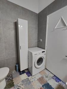 a bathroom with a washing machine and a washer at Asmini Beach Apartments in Asmínion