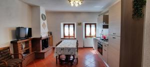 una cucina con tavolo e televisore in una stanza di Casa Badia a Radda in Chianti