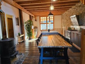 una cocina con una larga mesa de madera en una habitación en Charming 19th-century village home en Bons