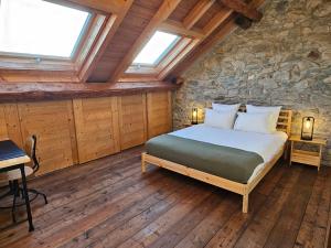 1 dormitorio con cama y pared de piedra en Charming 19th-century village home en Bons