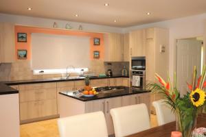 cocina con fregadero y mesa con sillas blancas en Opal Villa, en Palm-Eagle Beach