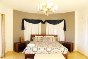 een slaapkamer met een bed en een kroonluchter bij Opal Villa in Palm-Eagle Beach