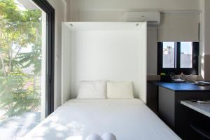 a small bedroom with a bed and a window at YAMAS Urban LIving Spiridonos in Limassol