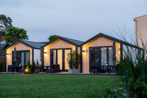 a house with glass doors on a lawn at Holiday Point in Międzywodzie
