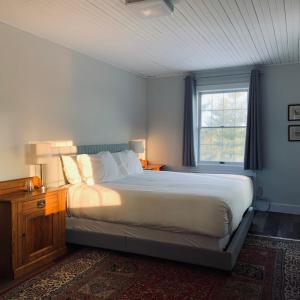 a bedroom with a large bed and a window at South Landing Inn in Niagara on the Lake
