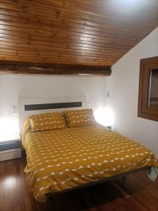 a bed in a bedroom with a wooden ceiling at APARTAMENT BETTY in Sort