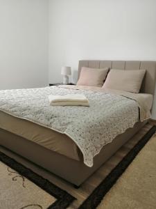 a bed in a bedroom with a white wall at Apartman Mihajlovic Brus in Brus