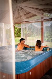 un homme et une femme dans un bain à remous dans l'établissement Hotel Ristorante Sa Pedrera, à Cabras