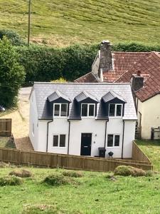 una casa blanca con un techo gris en un campo en Ruby's Retreat! Farm Stay! North devon! Beaches and Exmoor!, en Barnstaple