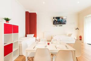 - une salle à manger blanche avec une table et des chaises blanches dans l'établissement Studio Apartment Friedrichshain, à Berlin