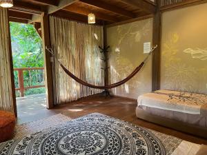 a room with a bed and a hammock in it at PUQIO ECOLODGE in Tarapoto