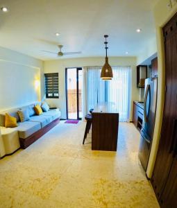a living room with a couch and a table and a tv at Lively condo in Zihua! in Zihuatanejo