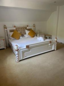 a bedroom with a white bed with yellow pillows at Forgemasters House in Telford