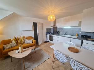 uma cozinha e sala de estar com um sofá e uma mesa em Duplex centre ville-bord de mer em Concarneau