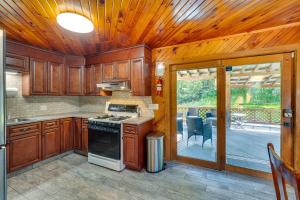 a kitchen with wooden cabinets and a stove at Cozy Livingston Manor Home with Wood-Burning Stove! in Livingston Manor