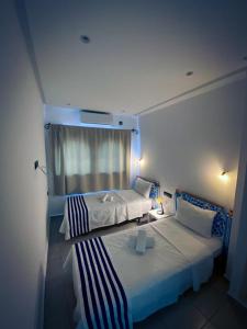 シェフシャウエンにあるHotel Marrakechのベッド2台と窓が備わるホテルルームです。