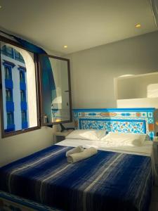 シェフシャウエンにあるHotel Marrakechのベッドルーム(鏡付きの青と白のベッド付)