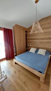 Un dormitorio con una cama azul y una lámpara de araña. en Lodge Les Oliviers en Garéoult
