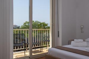 a bedroom with a bed and a balcony with a view at Nautika Suites in Alghero
