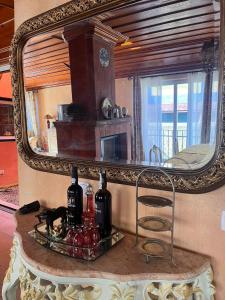 a mirror on a wall with bottles on a table at Casa de Santo Amaro in Sintra