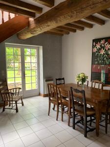 ein Esszimmer mit einem Holztisch und Stühlen in der Unterkunft Maison de Village Vexin site classé 1h Paris et Normandie grand jardin in Reilly