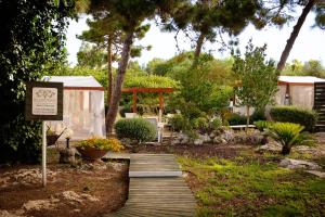 un giardino con passerella in legno con un cartello di Hotel Sa Pedrera a Càbras