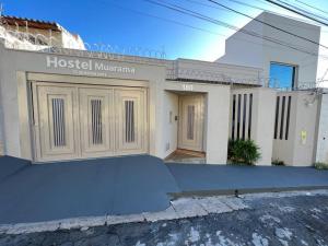 a house with a sign on the front of it at Hostel Muarama in Passos
