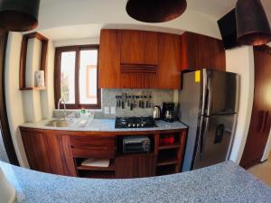 a kitchen with wooden cabinets and a stainless steel refrigerator at Boutique Condo Close to Everything in Zihuatanejo