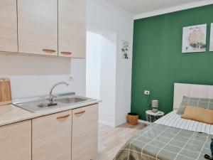 eine Küche mit einem Waschbecken und ein Bett in einem Zimmer in der Unterkunft Casa 21 - the cutest in Tirana! in Tirana