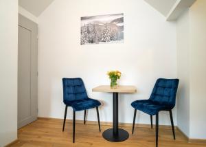 2 sillas azules y una mesa en una habitación en Fort63 apartments, en Kaunas