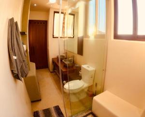 a bathroom with a toilet and a sink and a mirror at Boutique Condo Close to Everything in Zihuatanejo +22 photos