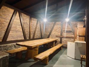 a dining room with a wooden table and benches at Cabana Miska Chalet in Miercurea-Ciuc