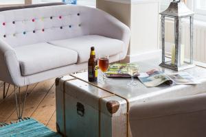 a living room with a couch and a table with a bottle and glasses at The Beach Hotel in Minehead