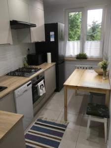 a kitchen with a stove and a table in it at Apartament Centrum in Suwałki