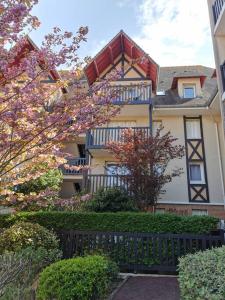 a large house with a fence in front of it at Cabourg cosy, appartement refait à neuf, 5 min à pied de la mer in Cabourg