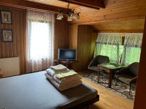 Habitación con cama, TV y mesa. en "Jurkówka" en Szczyrk