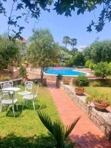 a garden with a table and chairs and a swimming pool at Ariel's beach house in Pefkohori in Pefkohori