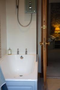 a bathroom with a white sink and a mirror at Balmungo Cottage B&B in St Andrews