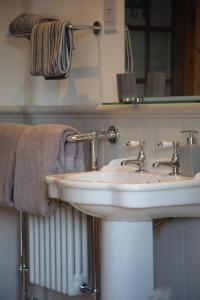 a bathroom with a sink and a mirror and towels at Balmungo Cottage B&B in St Andrews