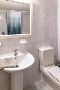 biała łazienka z umywalką i toaletą w obiekcie Eftihia Apartments by the sea w Retimnie +37 zdjęć