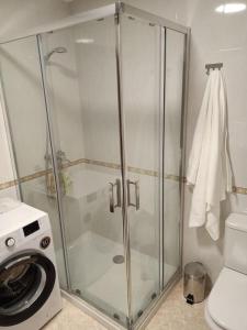een douchecabine in een badkamer met een wasmachine bij A casa do Porto in Valdoviño