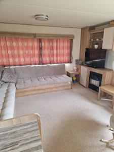 a living room with a couch and a television at Woods caravan in Ingoldmells