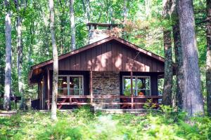 una cabaña de madera en el bosque con árboles en Mountain Springs Lake Resort en Stroudsburg