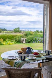 a table with a plate of food on top of it at Balmungo Cottage B&B in St Andrews