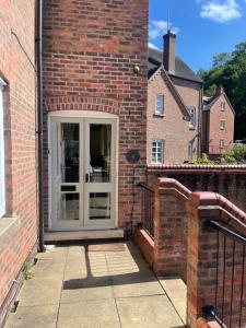 uma casa de tijolos com uma porta e uma varanda em Forgemasters House em Telford