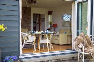 a patio with a table and chairs on a porch at Balmungo Cottage B&B in St. Andrews +67 photos