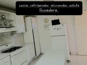 cocina blanca con nevera y fogones en casa habitacion el molino, en Tehuacán